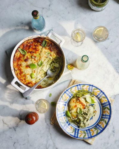 Vegetarische Lasagne in Auflaufform mit Löffel, Teller mit Lasagne und Getränkefläschchen