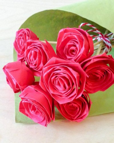 Strauß aus pinkfarbenen Papierrosen in grünem Papier