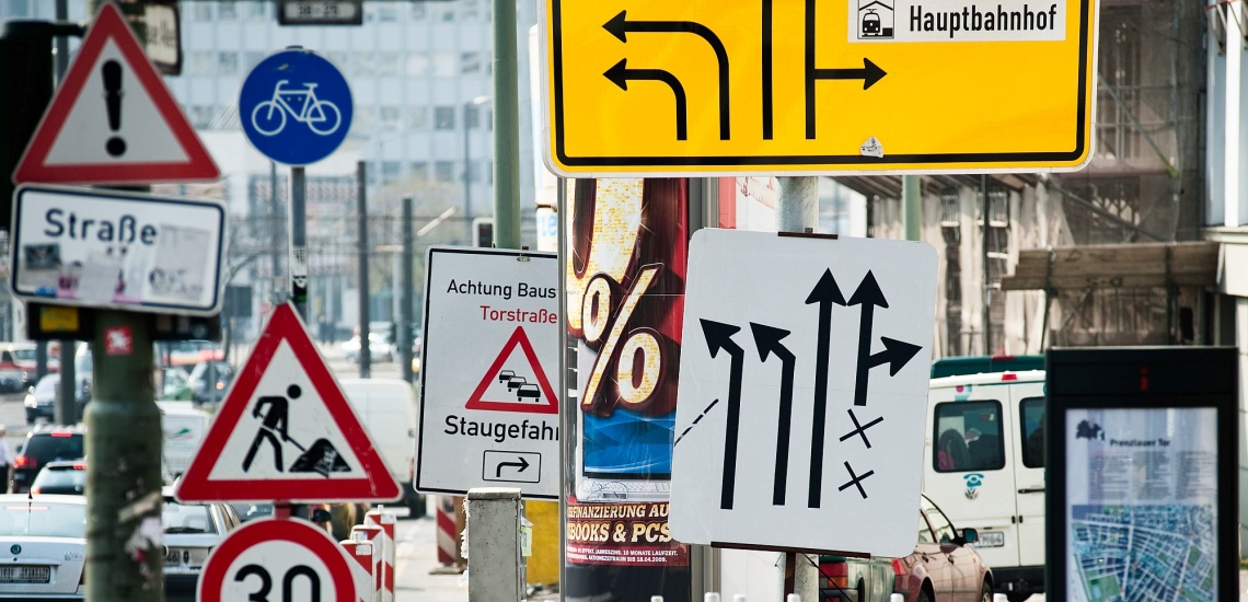 Sehr viele unterschiedliche Verkehrsschilder und Wegweiser in einer Stadt