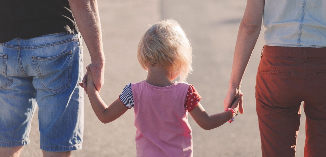 Kind hält Mutter und Vater an den Händen