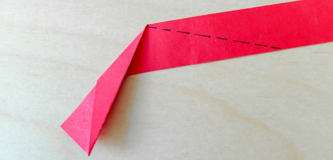 gefalteter und mit Linie markierter Papierstreifen