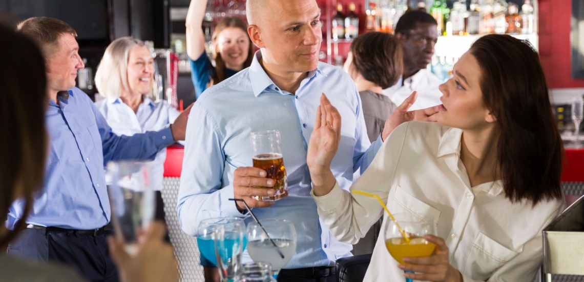 Frau in einer Bar wehrt Mann ab, der sie an der Schulter berührt hatte