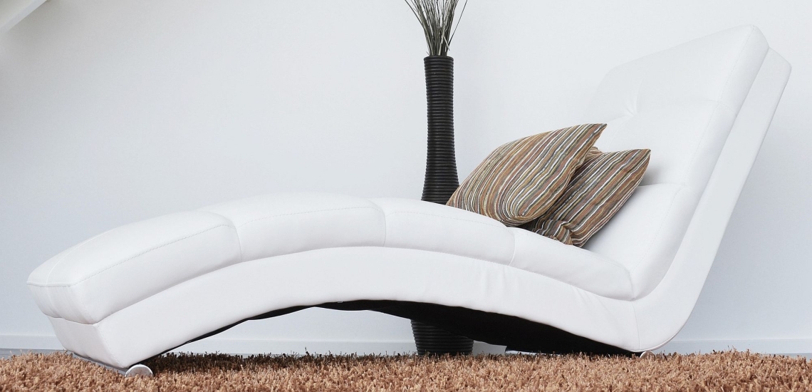 Gemütlicher Sessel mit Kissen auf Teppich