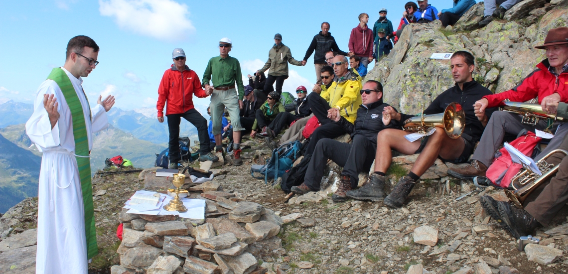 Pater Peter Rinderer predigt vor Wanderern und Bergsteigern auf dem Berg