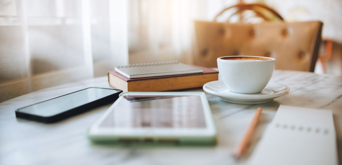 Handy Tablet Bücher Notizbuch Tasse und Stift auf Tisch