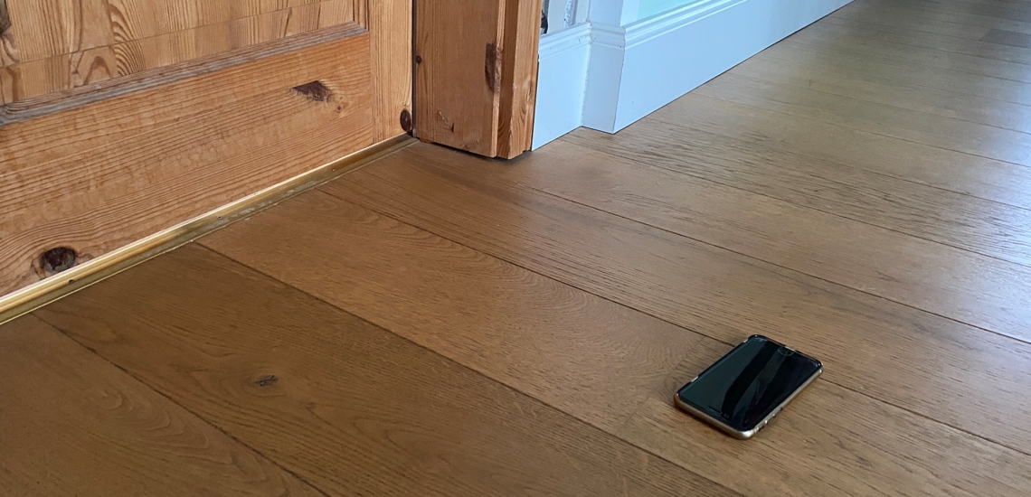 Ein Handy liegt auf dem Boden vor der Zimmertür