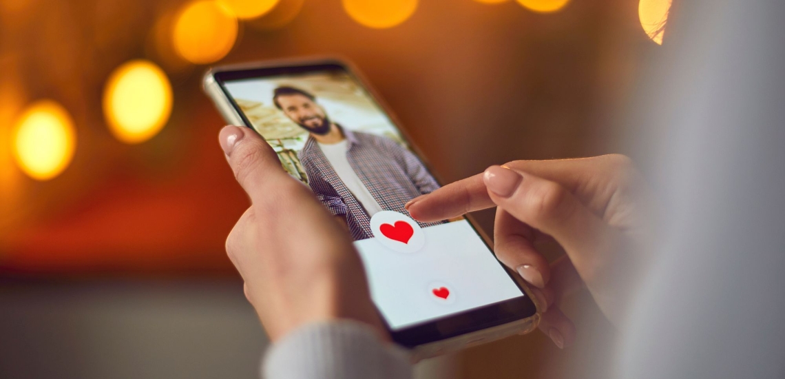 Frauenhände tippen auf Handy mit Dating-App