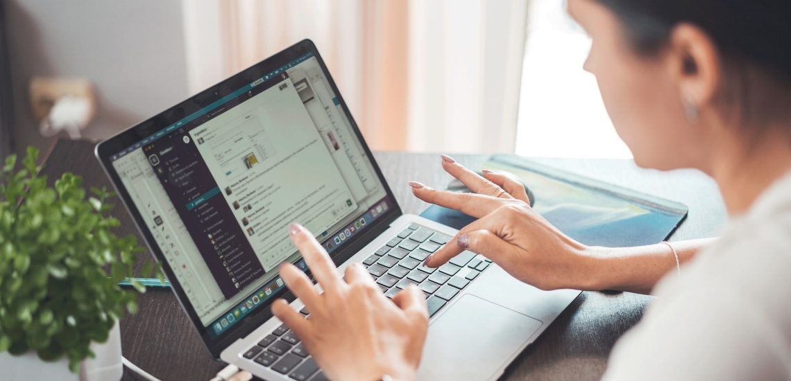 Frau sitzt am Laptop und tippt