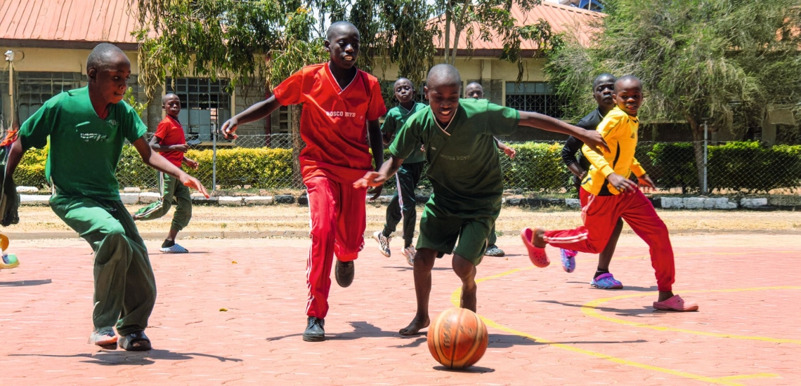 Kinder spielen Fußball auf Sportplatz im Don Bosco Zentrum in Nairobi