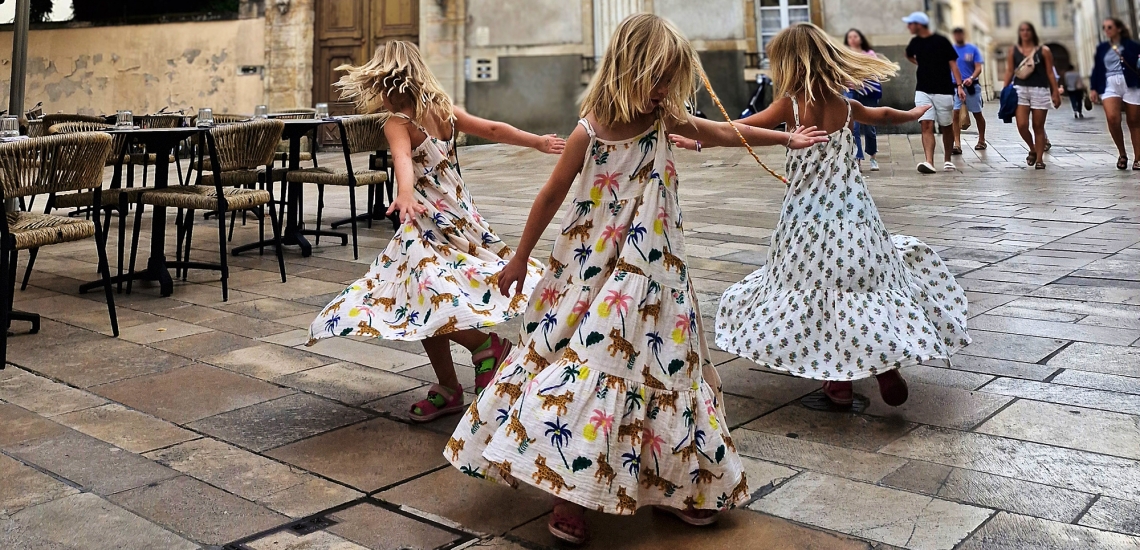 Drei Mädchen in lange Kleidern tanzen im Kreis