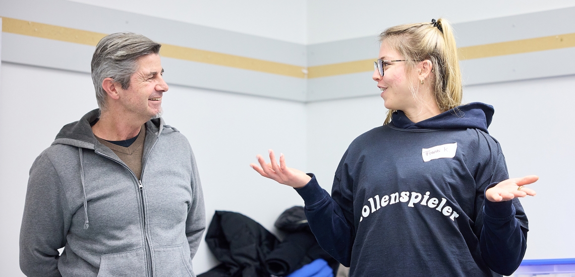 Ralph Kappelmeier und Franzi stehen sich gegenüber. Franzi trägt ein T-Shirt mit der Aufschrift "Rollenspieler".