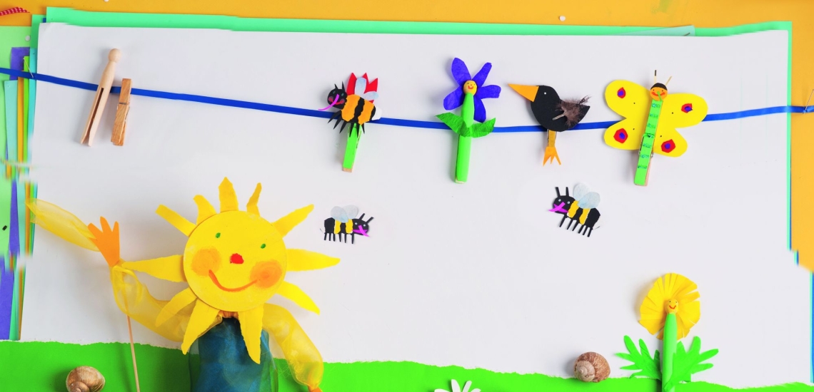 Girlande mit Biene, Blume, Vogel und Schmetterling aus bunt bemalten Wäscheklammern und Papier