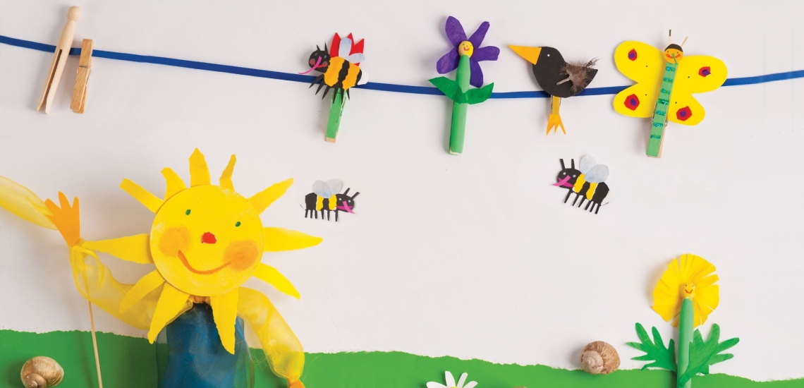 Girlande mit Biene, Blume, Vogel und Schmetterling aus bunt bemalten Wäscheklammern und Papier