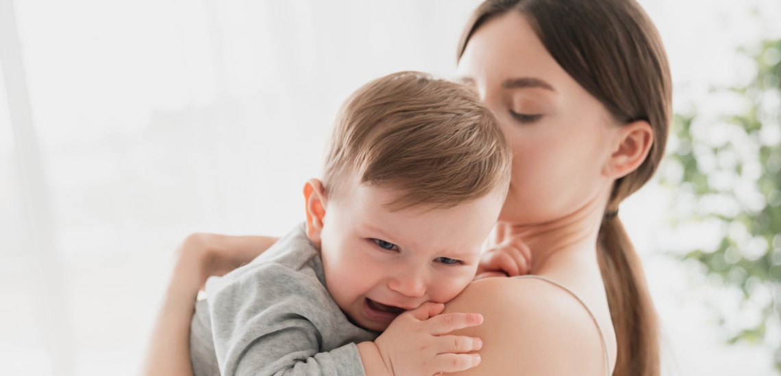 Baby weint auf Arm der Mutter
