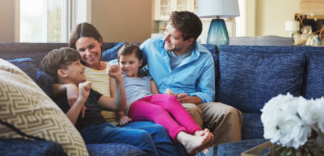 Eltern und Kinder unterhalten sich angeregt auf Sofa