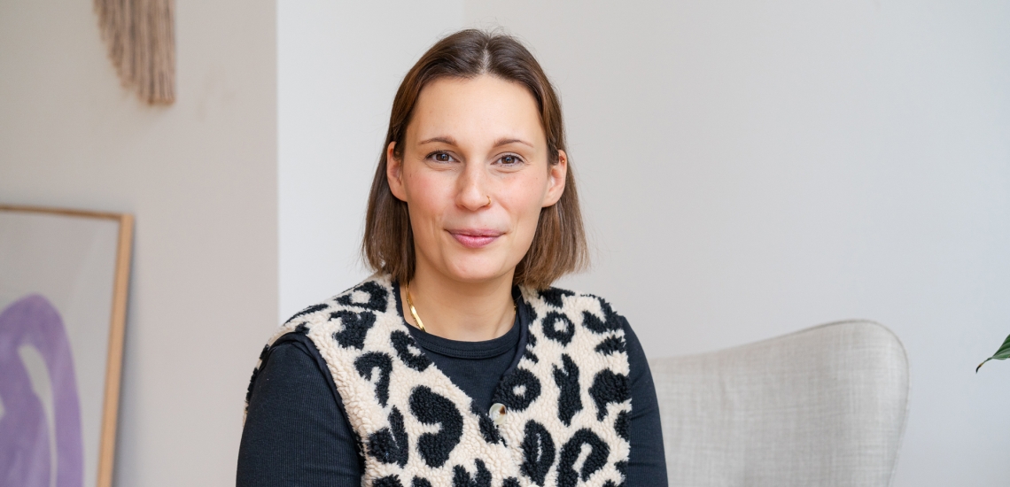 Eine Frau Anfang 30 mit schulterlangem braunem Haar blickt freundlich in die Kamera.