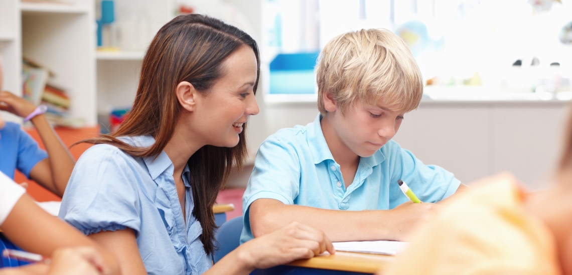 Eine Lehrerin erklärt einem Schüler während des Unterrichts etwas.