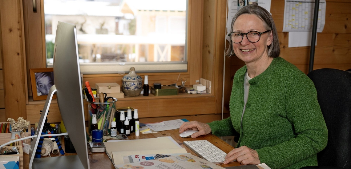 Karin Buchart am Schreibtisch vor Bildschirm