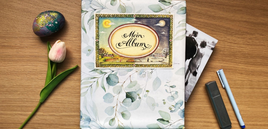 Album mit Aufschrift Mein Album, daneben Blume, bemalter Stein und Stifte