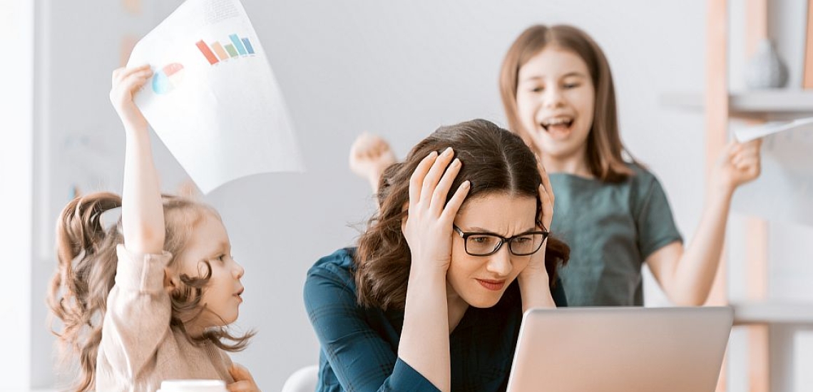 Mutter sitzt am Laptop und will sich konzentrieren, zwei Kinder toben um sie herum