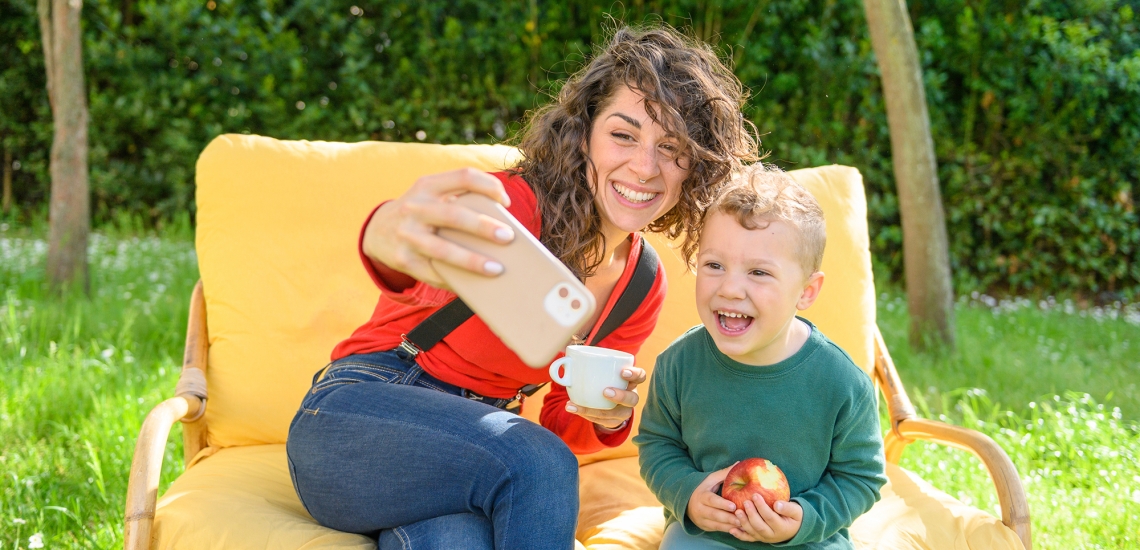 Eine Mutter macht im Garten ein Selfie mit ihrem Sohn.