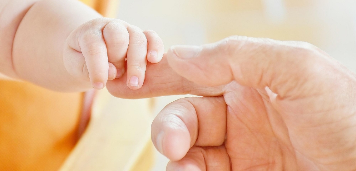 Babyhand hält Erwachsenenhand