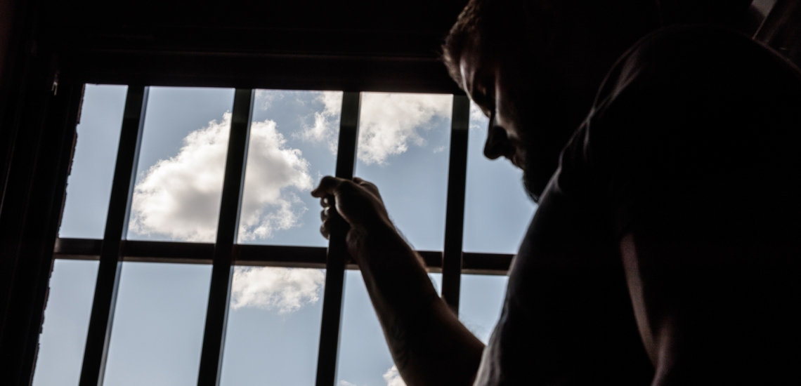 Inhaftierter am vergitterten Fenster