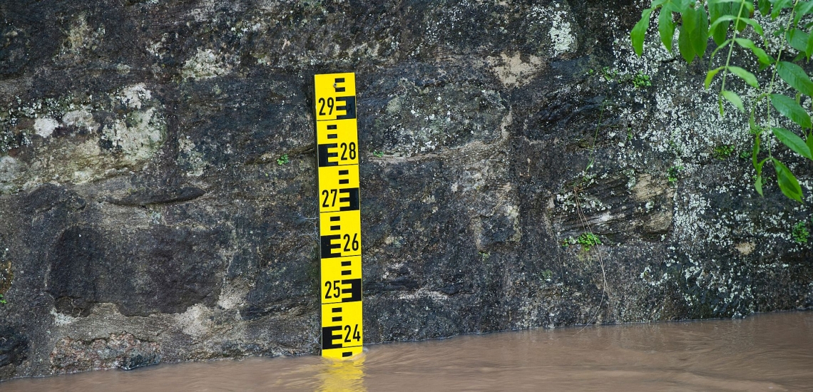 Ein an eine Steinmauer angebrachter Pegel zeigt den Wasserstand an