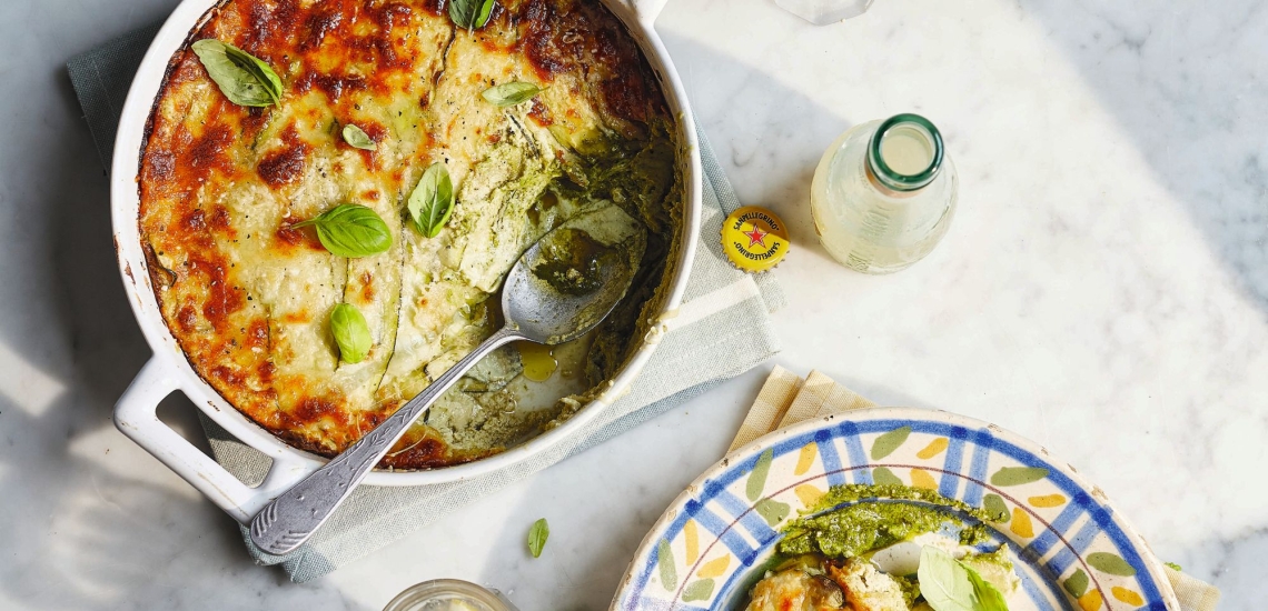 Vegetarische Lasagne in Auflaufform mit Löffel und Getränkefläschchen