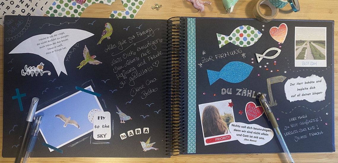 Gestaltete Doppelseite eines Scrapbooks: schwarze Seiten mit Texten, Zeichnungen, Stickern und Fotos zur Firmung
