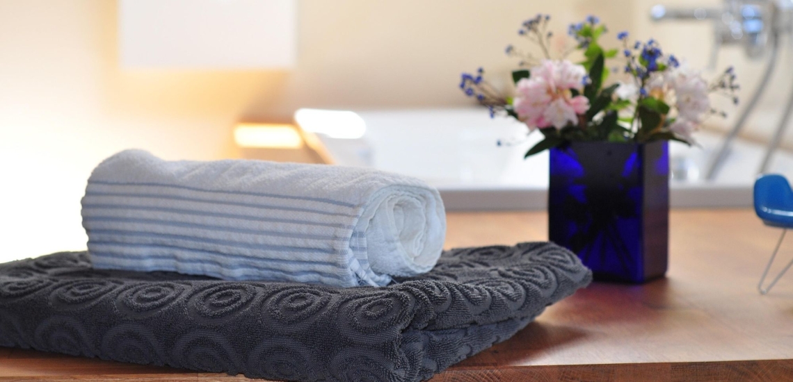 Handtücher und Blumen in entspannter Atmosphäre im Bad