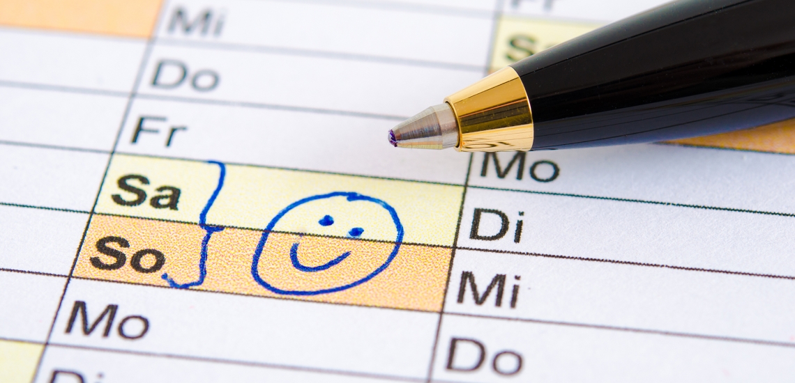 Kalender, in dem ein Samstag und Sonntag mit einem Smiley markiert sind, Kugelschreiber