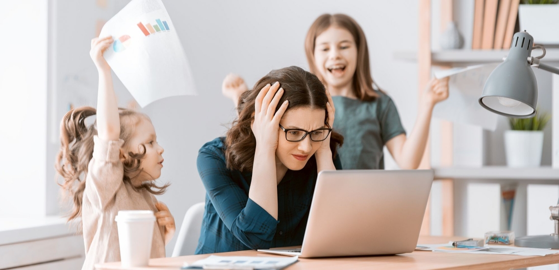 Mutter sitzt am Laptop und will sich konzentrieren, zwei Kinder toben um sie herum