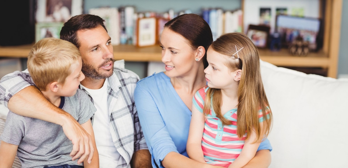 Eltern und Kinder sitzen eng zusammen und sprechen angeregt miteinander