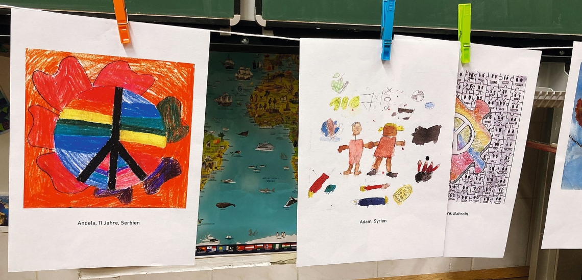 Kunstwerke von Kindern und Jugendlichen zum Thema Frieden hängen an einer Wäscheleine