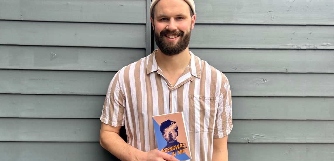 Mann mit Vollbart hält Buch