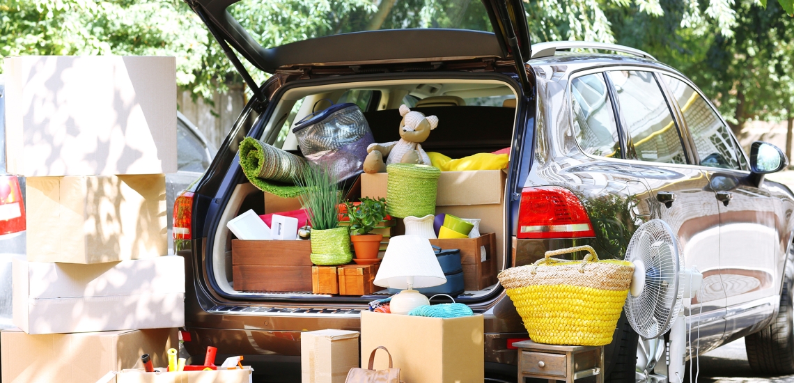 Kombi mit offener Heckklappe, im Kofferraum und drumherum Kartons, Taschen, Lampen use.