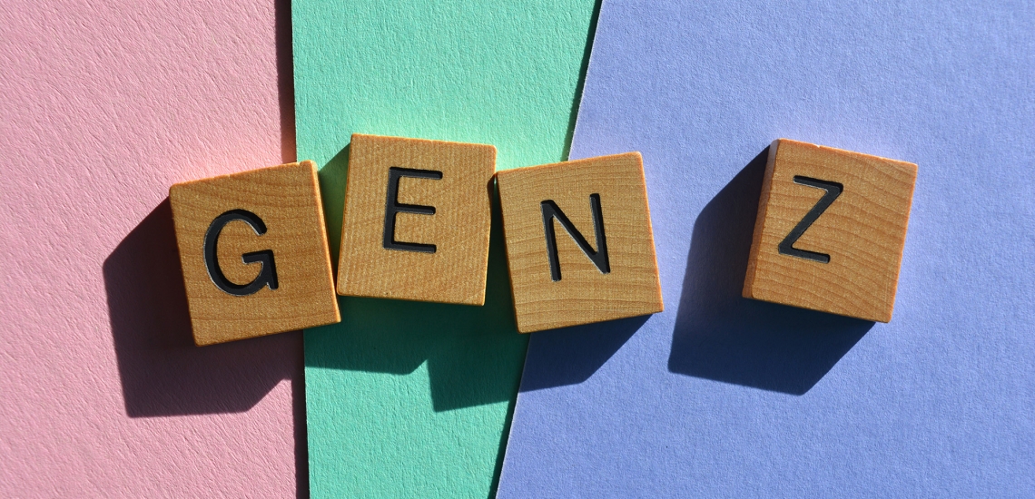 Auf vier Holzwürfeln stehen die Buchstaben G, E, N, Z. Der Hintergrund ist farbig.