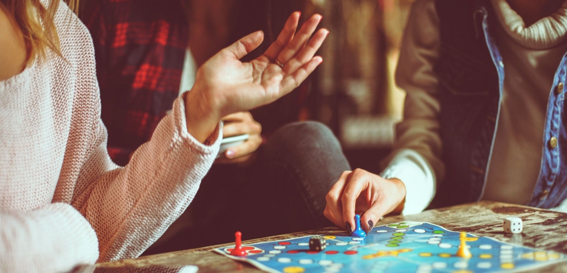Hände gestikulieren und würfeln auf Brettspiel