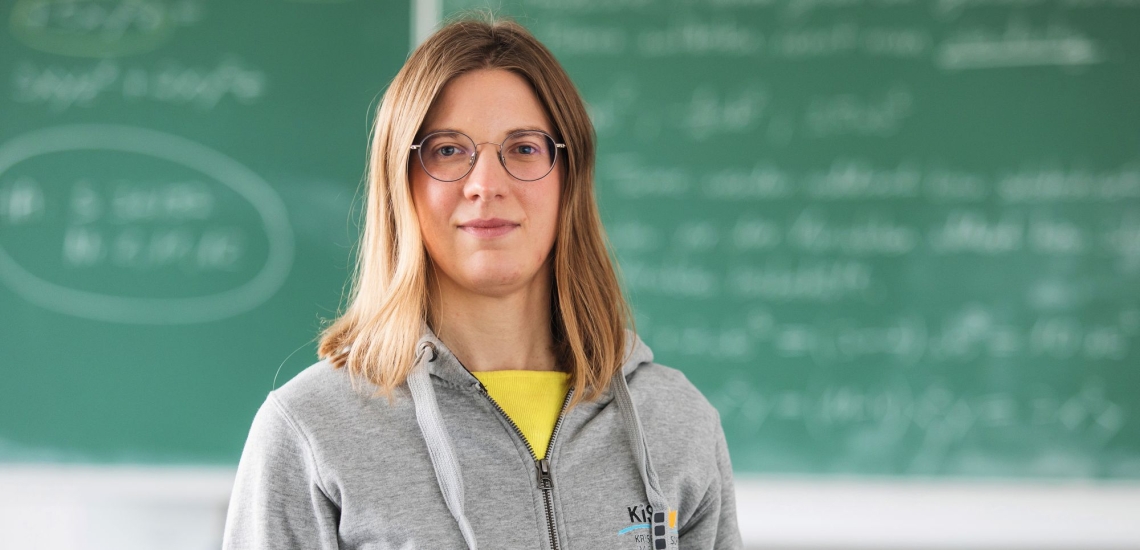 Lehrerin vor Tafel in Klassenzimmer 