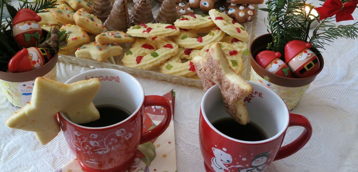 Plätzchen und Tassen mit weihnachtlicher Dekoration 