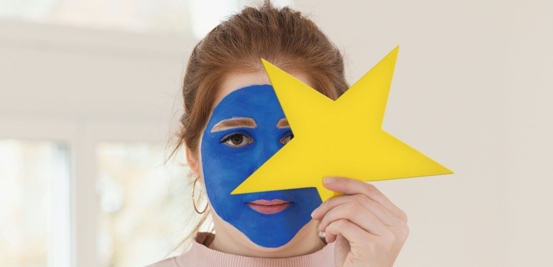 Porträt junge Frau mit blauer Schminke und gelbem Stern 