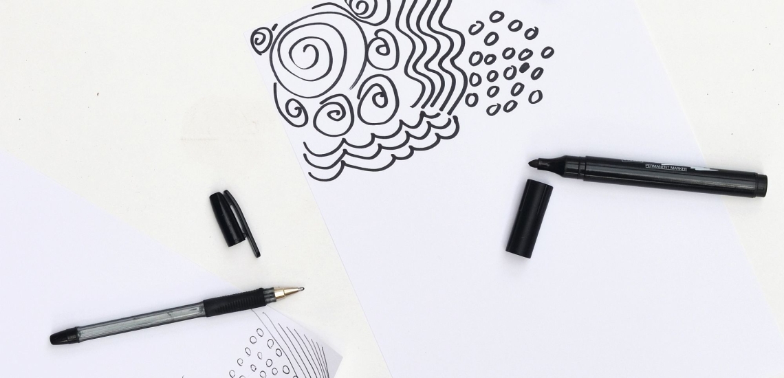 Filzstifte und Muster auf weißem Papier 