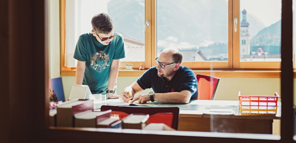 Lehrer und Schüler bei Studierzeit im Büro 