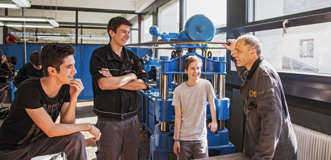 Schüler mit Lehrer vor Maschinen 