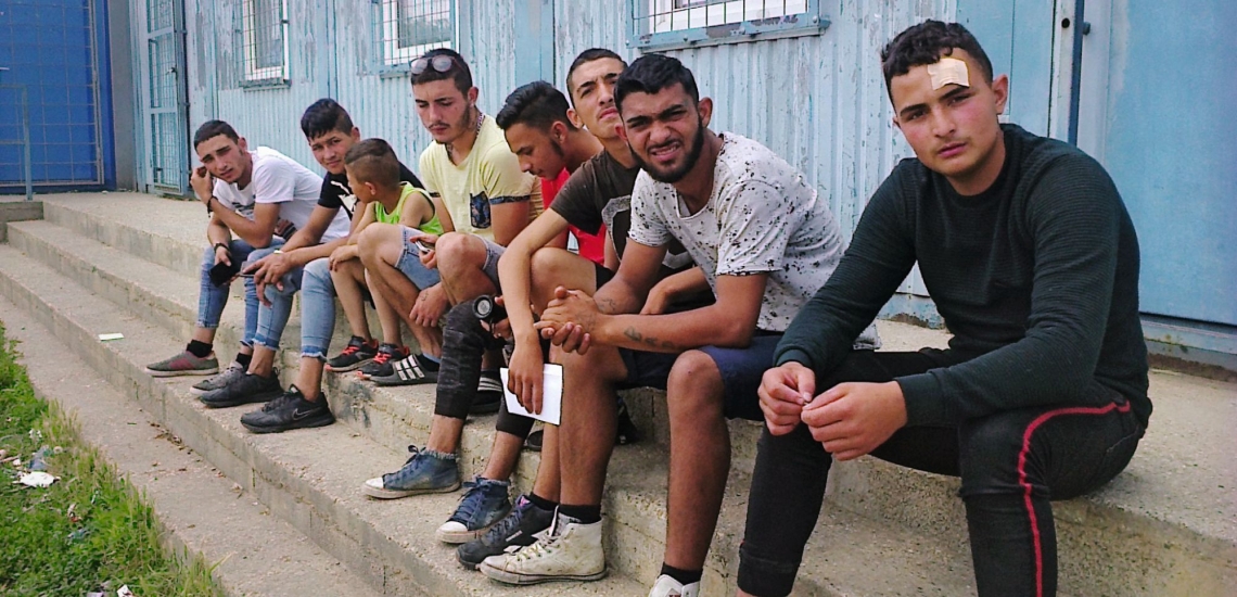 Jugendliche auf Treppe vor Container 