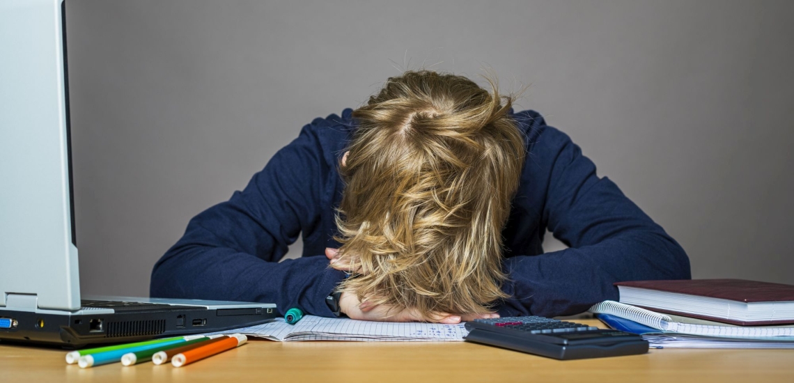 Jugendlicher verzweifelt über Schulbüchern 