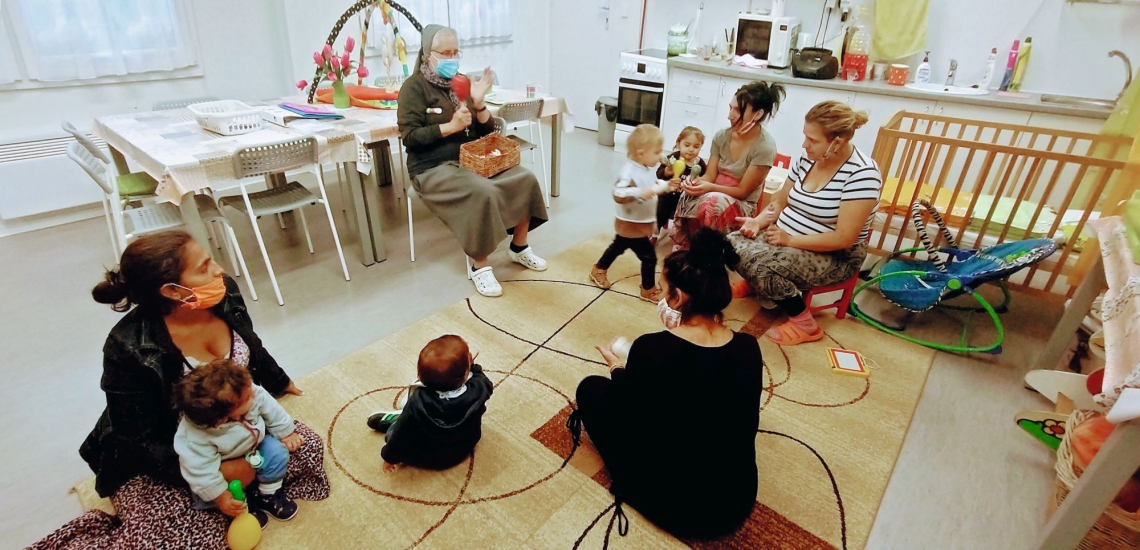 Mütter und Kinder mit Schwester in Gruppenraum 