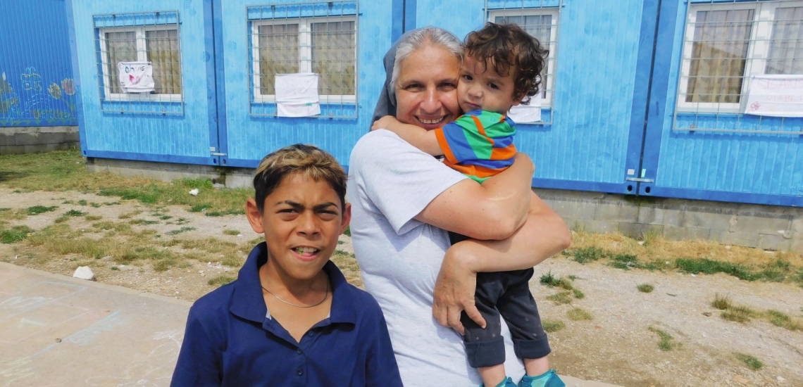 Schwester mit zwei Kindern vor Container 