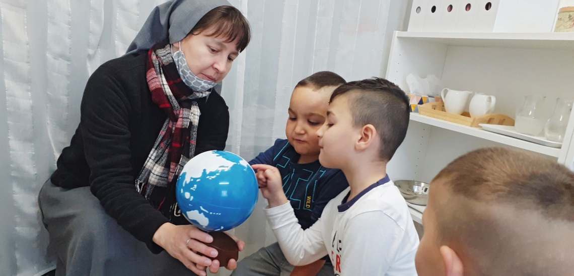 Schwester mit Kindern und Globus 